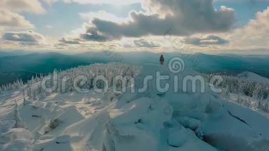 无人机飞行：徒步旅行者<strong>站在</strong>雪<strong>山顶</strong>的岩石上，欣赏风景